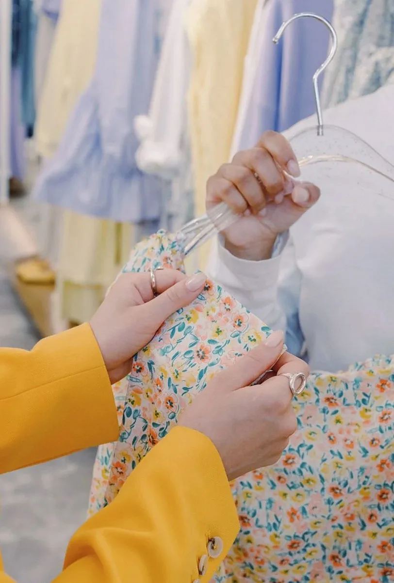 花柄の服をハンガーごと二人で見ている手元